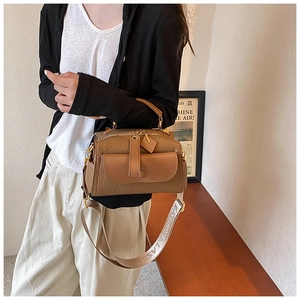 Dettaglio borsa in pelle martellata marrone con tracolla larga e finiture dorate