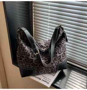 Detail of leopard print tote bag featuring black leather trim and white contrast stitching
