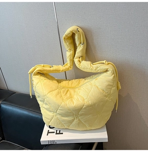 Detailed view of lemon yellow quilted hobo bag featuring heart patterns and soft fabric
