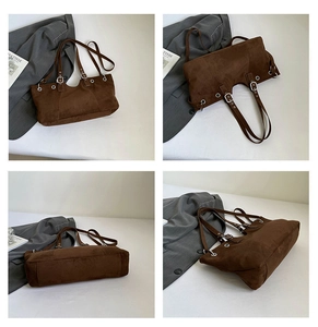 Detailed close-up of brown faux suede tote bag with metallic eyelets and adjustable strap