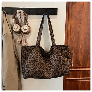 Detailed view of the leopard print tote bag hanging with long straps for commute