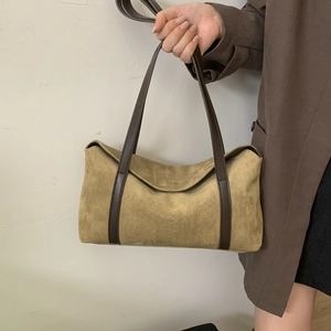 Detail of minimalist khaki suede shoulder bag with deep brown leather strap and stitching