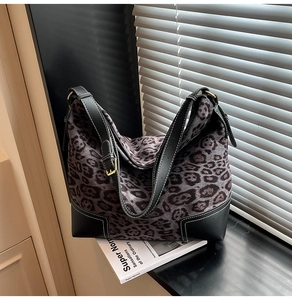 Detail of leopard print tote with black leather trim and white contrast stitching