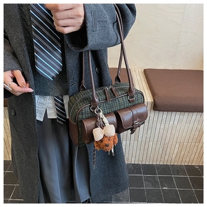 Détail du sac à bandoulière vintage à carreaux verts avec breloque ours et rabats