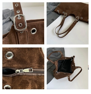 Detail view of dark brown suede tote bag with silver metal buckles and zip closure