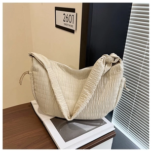 Detail shot of beige quilted hobo bag with drawstring and stylish knotted shoulder strap