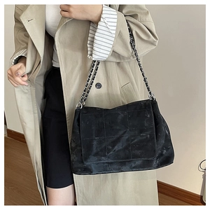 Détail du sac à bandoulière matelassé noir avec bandoulière chaîne sur le modèle