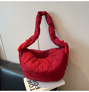 Detail of red heart quilted puffer tote bag with side drawstring and padded handle