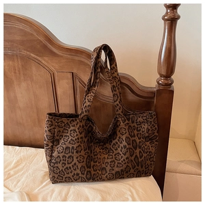 Detail of leopard print fabric texture on a large capacity tote bag with wide handles