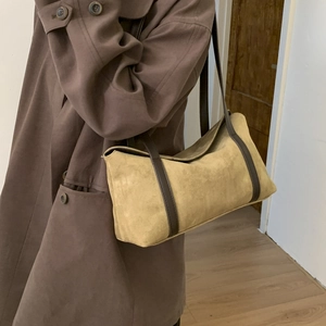 Detail of vintage pillow bag in khaki suede and brown leather strap on model