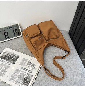 Détail du sac à bandoulière vintage en toile marron caramel avec de multiples poches