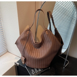 Detail of premium brown woven leather texture on a spacious commute tote bag