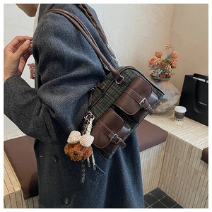 Détail du sac oreiller à carreaux vintage avec deux poches et breloque ourson