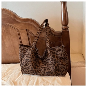 Detailed view of large leopard print tote bag on a warm wooden background for daily commute