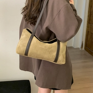 Detail showing the khakisuede texture and brown leather strap of the vintage shoulder bag