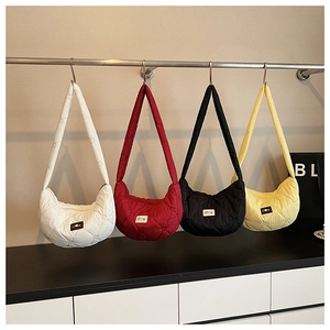 Quilted heart pattern crossbody bags in four colors hanging on a display rack