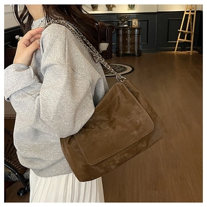 Détail du sac à bandoulière matelassé marron avec bandoulière en chaîne argentée