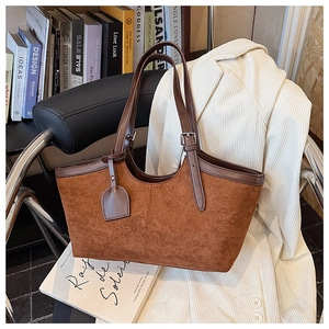Detail of vintage brown suede tote bag featuring contrast leather handles and vertical stitching