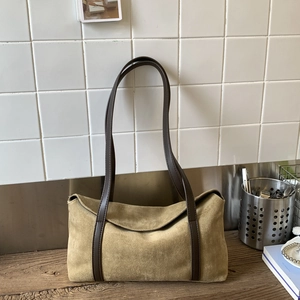 Minimalist olive suede baguette shoulder bag with brown leather straps on wood table