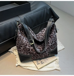 Close-up of leopard print hobo bag with black leather corners and white contrast stitching