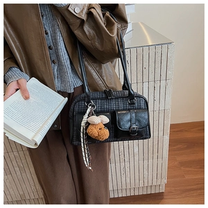 Détail du sac bandoulière vintage à motif pied-de-poule avec pendentif ours et boucle