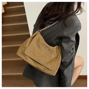 Gros plan du sac fourre-tout rétro caramel avec texture matelassée et bandoulière chaîne