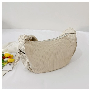 Detail of beige pleated crescent bag with zipper and adjustable side buckles