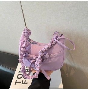 Détail du sac fourre-tout plissé lilas avec décoration de nœud et bandoulière à volants
