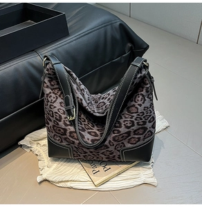 Detail of leopard print tote bag with black leather trim and contrast white stitching