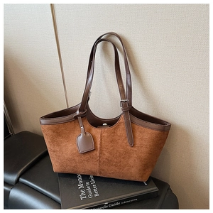 Detail of vintage suede tote bag showing contrast straps and adjustable metal buckle