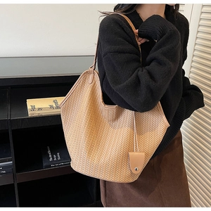 Detailed herringbone weave texture on a large brown woven tote bag for autumn