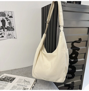 Détail du sac cabas en toile crème avec poches latérales et bandoulière