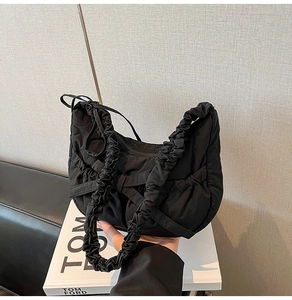 Gros plan détaillé d'un sac hobo matelassé noir avec texture plissée et tissu souple