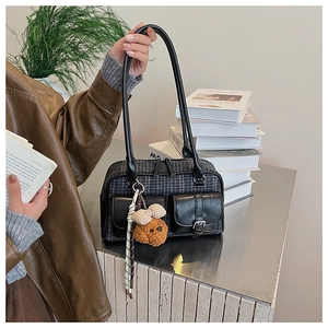 Détail d'un sac à main pied-de-poule rétro avec poches, breloque peluche et foulard en soie