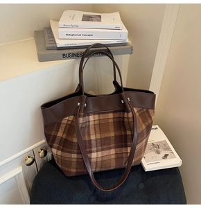 Gros plan du sac cabas rétro à carreaux marron avec sangles en cuir sur fond épuré