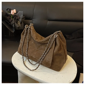 Détail du sac vintage marron avec texture matelassée et chaîne argentée sur table