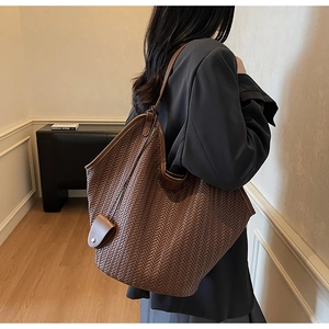 Macro detail of the brown woven tote bag showing premium texture and Intrecciato craft