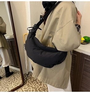 Detailed view of black nylon dumpling bag with adjustable shoulder strap for daily commuting