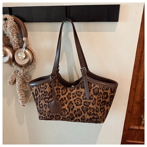 Close-up of leopard print tote bag with adjustable leather straps and metal buckle detail