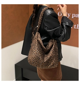 Detailed side view of the oversized leopard print hobo bag worn by a model for styling
