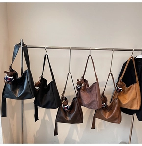 Détail de grands sacs seaux avec breloques d'ours en quatre couleurs tendance