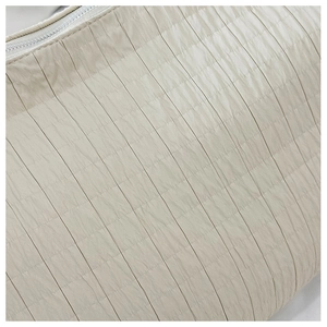 Detail of light beige pleated nylon fabric and top zipper of the tote bag