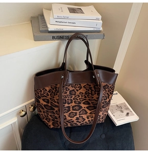 Détail d'un grand sac cabas avec imprimé léopard marron et bordures en cuir foncé