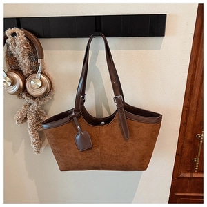 Detailed view of adjustable brown leather straps on a vintage suede tote bag