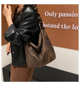 Close-up detail of leopard print patterns and scrunched shoulder strap on tote bag