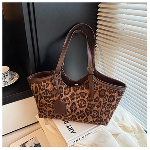 Detail of leopard print tote bag with brown leather handles and vintage props