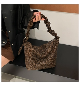 Close-up of leopard print hobo bag with ruched cloud handle on a seated model
