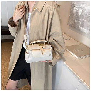 Borsa a bauletto crema chic con tracolla decorata e trama martellata su un modello