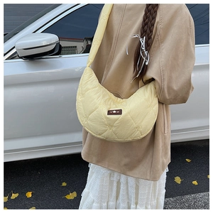 Gros plan d'un sac demi-lune jaune vif avec des détails de surpiqûres en forme de cœur