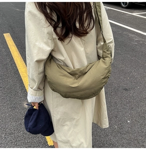Olive green nylon crescent bag showing large capacity and comfortable crossbody fit